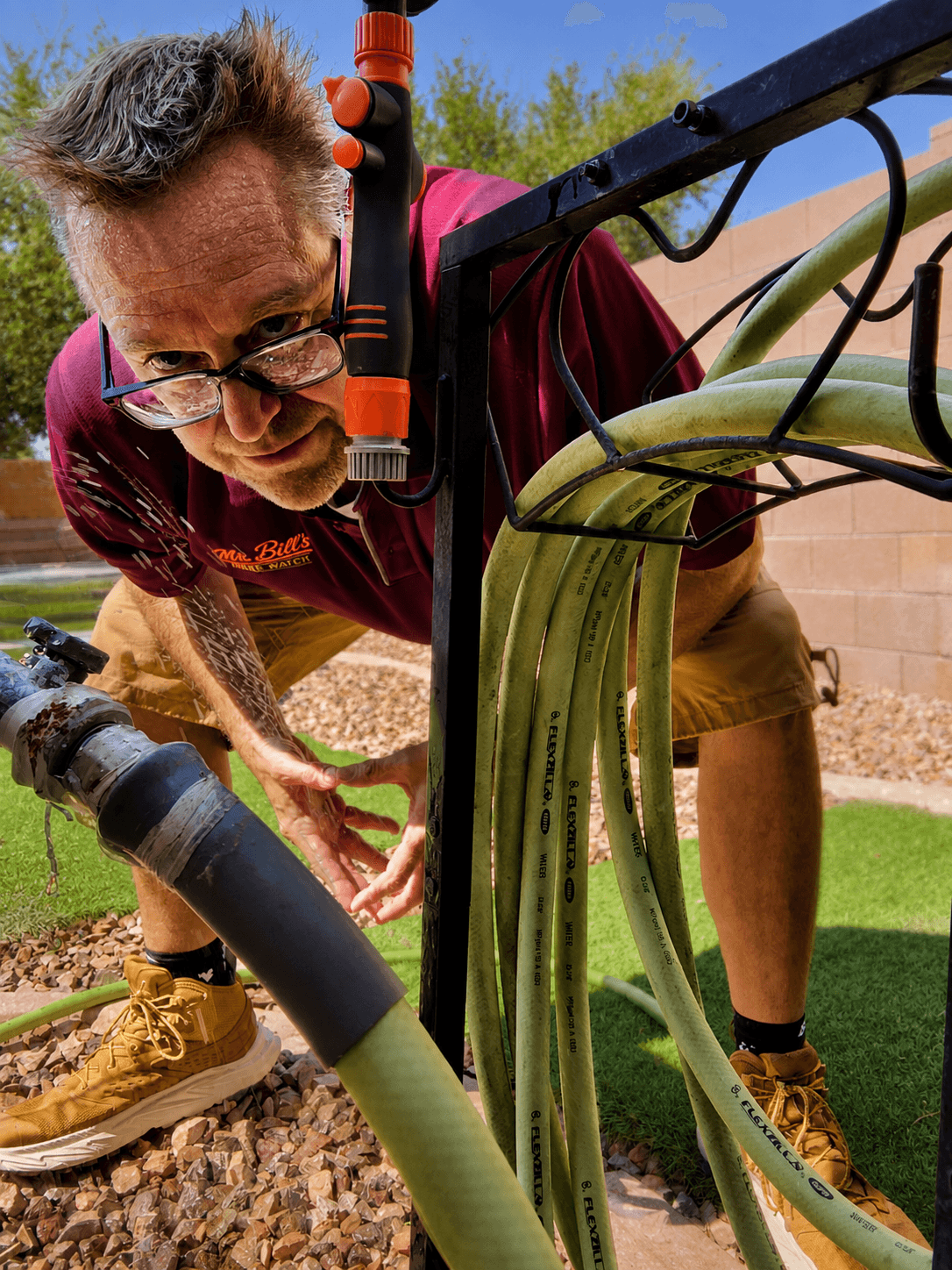Checking an exterior hose bib for leaks during a home watch visit
